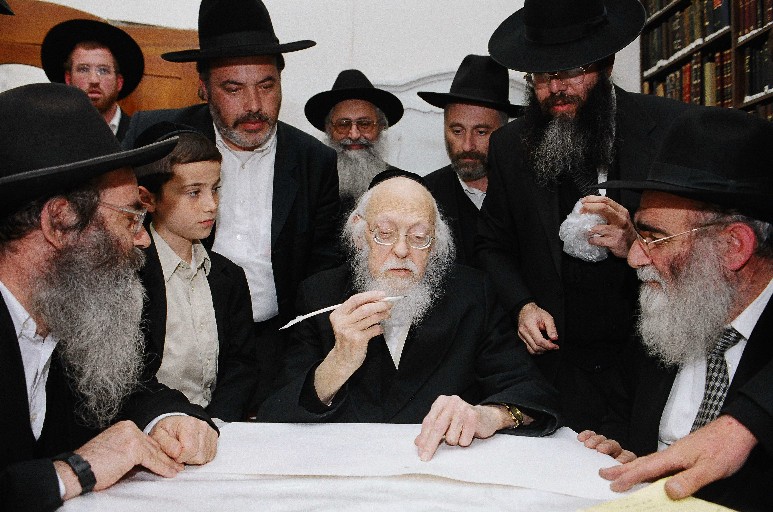 Rav Eliyashiv writing the first letter of the Toldos Yeshurun's Torah scroll.